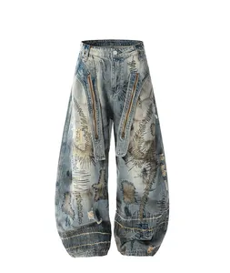 Dettaglio dei jeans in denim délavé a gamba larga con ricami pesanti e accenti di zip