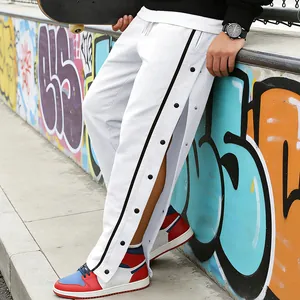 Detail van de witte heren joggingbroek met handige drukknopen aan de zijkant van de benen