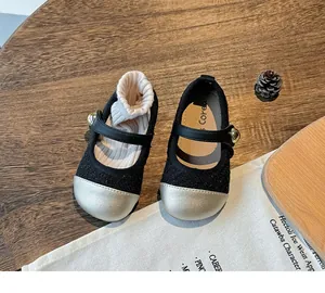 Close-up detail of black girls' princess shoes with silver toes and gold bead accents