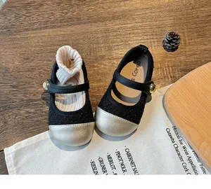 Detailed shot of elegant black girls' princess shoes featuring a shiny gold toe cap