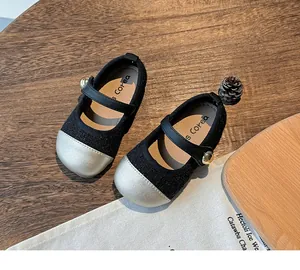 Detailed macro view of black fabric girl's Mary Jane shoes with silver toe cap