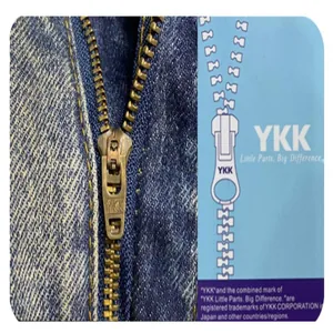 High-quality close-up macro view of a durable YKK metal zipper on blue washed denim jeans