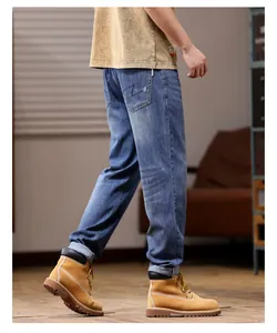 Men's blue straight-leg denim jeans styled with tan boots in a professional lifestyle shot