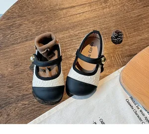 Detail view of children's Mary Jane shoes with tweed fabric and black toe caps.