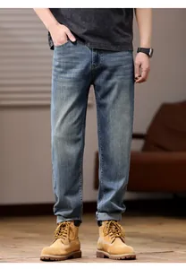 Classic blue men's loose stretch straight-leg denim jeans styled with tan work boots