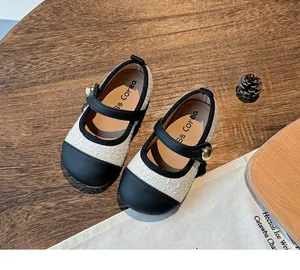 Detail of elegant girl's tweed princess shoes with black toe cap and gold bead strap