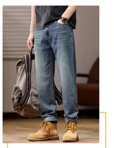 Men's loose stretch straight-leg blue jeans styled with work boots and backpack