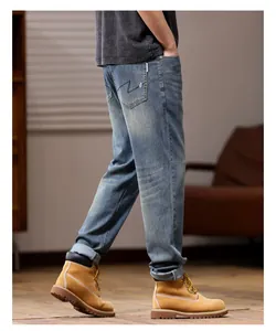 Men's loose fit straight leg stretch blue denim jeans shown from a back lifestyle view