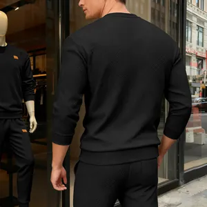 Rückansicht eines Mannes in einem schwarzen strukturierten Sweatshirt mit geometrischem Muster