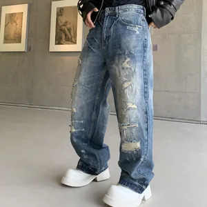 Jean déchiré bleu délavé à coupe droite et décontractée dans un décor de galerie d'art