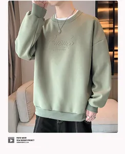 Jeune homme portant un sweat-shirt à col rond vert olive ample avec texte en relief