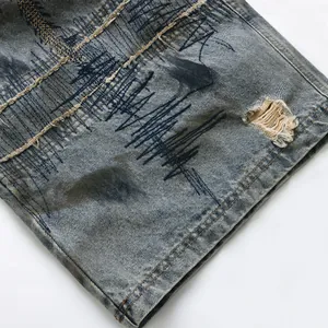Jeans in denim blu stile wasteland con ricami pesanti e dettagli strappati