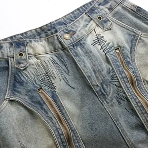 Pantaloni in denim stile high street blu invecchiato con ricami pesanti e dettagli zip elaborati