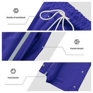 Detailweergave van de blauwe tear-away broek met tailleband, zak en drukknopen.