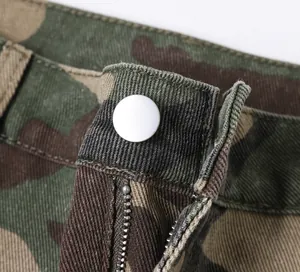 Close-up view of the metallic button and zipper on these camouflage cargo pants.