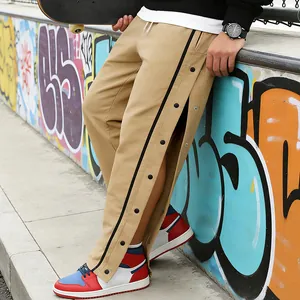 Detail van de kaki herenbroek met drukknopen in streetwear-stijl