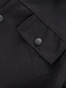 Gros plan sur la texture gaufrée noire avec poche et bouton-pression mat
