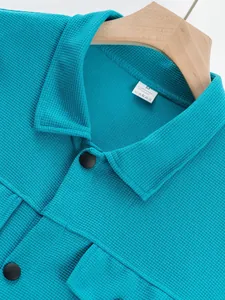 Gros plan sur la texture gaufrée et le col d'une veste de travail décontractée turquoise