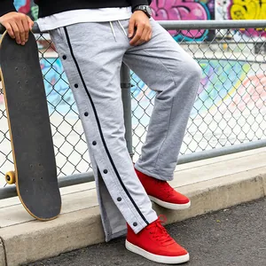 Detailweergave van grijze broek met zijknopen en een losse, comfortabele pasvorm