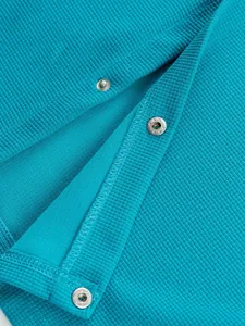 Détail en gros plan de la texture en maille gaufrée bleue avec boutons-pression argentés