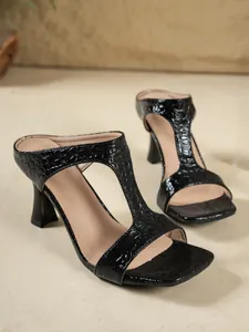 Primo piano di sandali neri con tacco effetto coccodrillo e punta quadrata alla moda