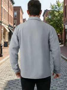 Vue arrière détaillée d'une veste de travail grise texturée sur une rue pavée