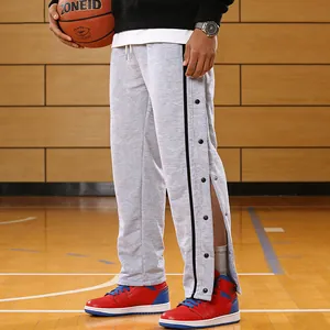 Detailopname grijze heren sportbroek met drukknopen aan de zijkant op het basketbalveld