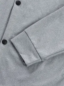 Gros plan détaillé sur la texture gaufrée grise d'une veste avec des boutons noirs