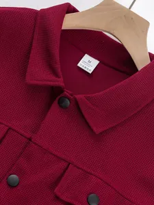 Vue détaillée d'une élégante veste bordeaux en maille gaufrée avec boutons noirs et col