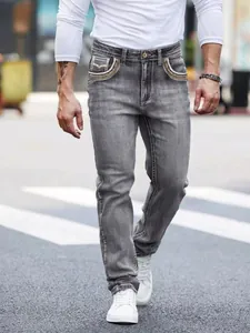 Men's stylish grey wash denim jeans with unique yellow and white embroidered pockets.