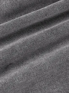 Close-up detail of grey denim fabric texture showing the twill weave on men's jeans