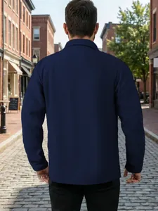 Vue arrière détaillée d'une veste de travail texturée bleu marine en milieu urbain.