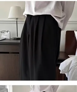 Vista dettagliata della trama del tessuto dei pantaloni da abito neri larghi da uomo