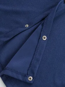 Vue détaillée du tissu gaufré bleu marine avec des boutons-pression en métal