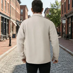 Vue arrière d'une veste de travail beige décontractée avec col à revers dans une rue pavée