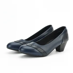 Detail view of stylish navy blue low block heel pumps with snake-skin pattern accents.