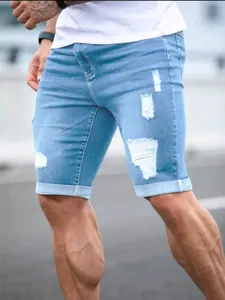 Close-up detail of men's light blue distressed ripped denim shorts for summer wear