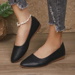 Primo piano di scarpe basse casual nere indossate con jeans in denim consumati trendy
