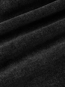 Macro detail of black denim fabric texture with visible diagonal twill weave pattern.