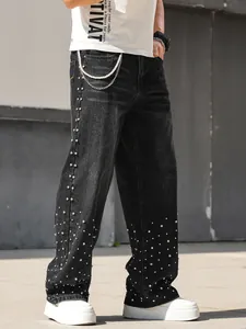 Detailed view of men's loose straight-leg black denim jeans with sparkly rhinestone decor