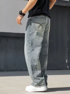 Detail view of men's loose straight denim jeans with rhinestone studded embellishments
