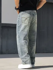 Detail view of men's loose straight jeans with sparkling rhinestone embellishments.