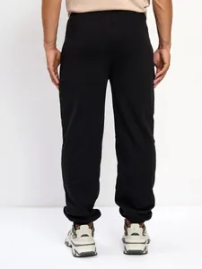Back view of men's black fleece joggers with elastic cuffs for comfortable casual wear