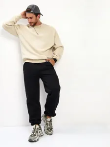 Detail view of men's oversized black fleece sweatpants for casual everyday comfort