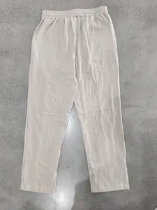 Detail of men's breathable beige linen trousers showing the back pocket and elastic waist.