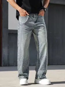 Close-up of men's loose straight blue jeans featuring sparkling rhinestone details