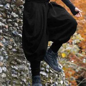 Vue détaillée du pantalon sarouel noir pour hommes dans un cadre extérieur rustique.