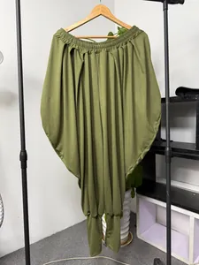 Détail du pantalon sarouel drapé vert olive avec une taille élastique et des ourlets.