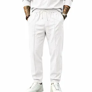 Front view of men's white cotton linen trousers featuring a loose straight-leg design.