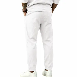 Back view detail showing the fit of white cotton linen loose straight-leg trousers for men